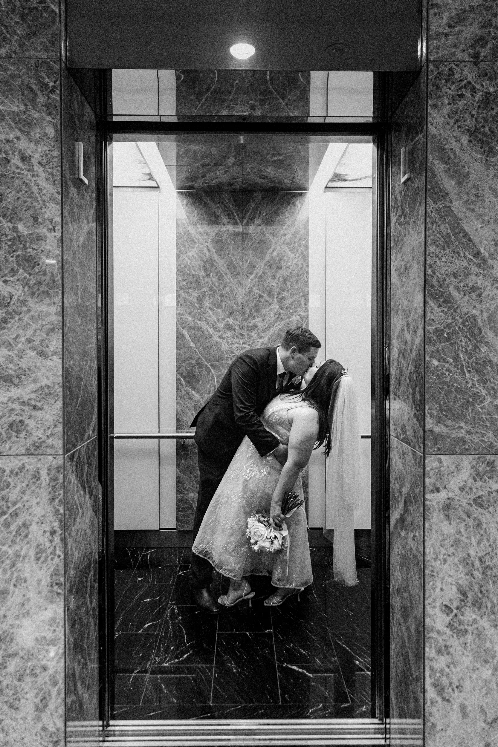 Carlie and Iain unique black and white intimate moment inside marble elevator creating romantic urban setting