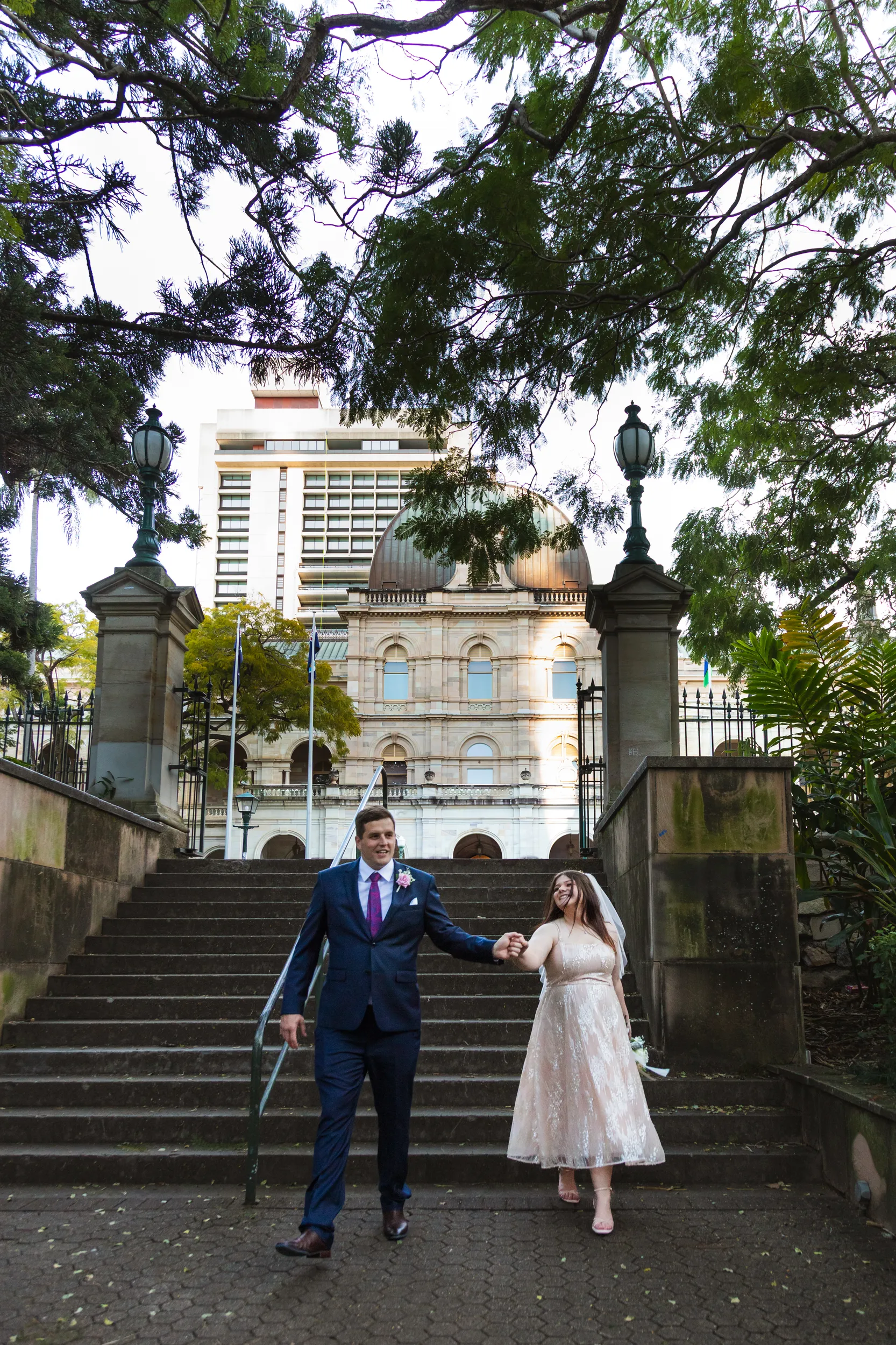 Carlie and Iain classic wedding portrait on stone steps in front of historic domed building with ornate architecture