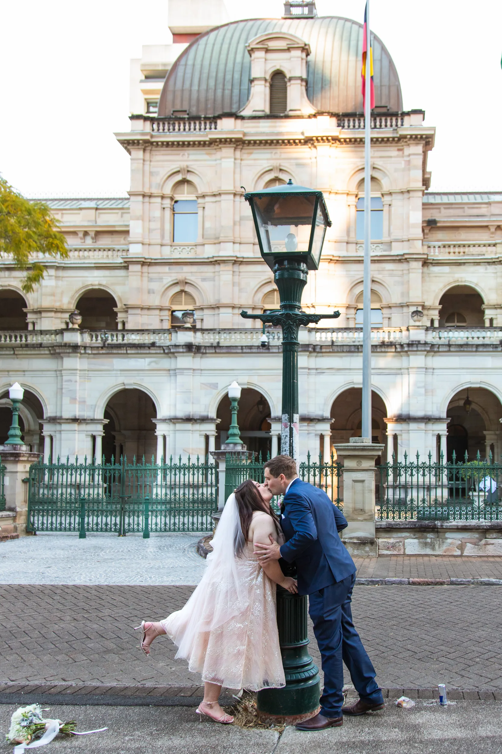 Carlie and Iain romantic kiss by vintage street lamp in front of magnificent historic building with classical architecture