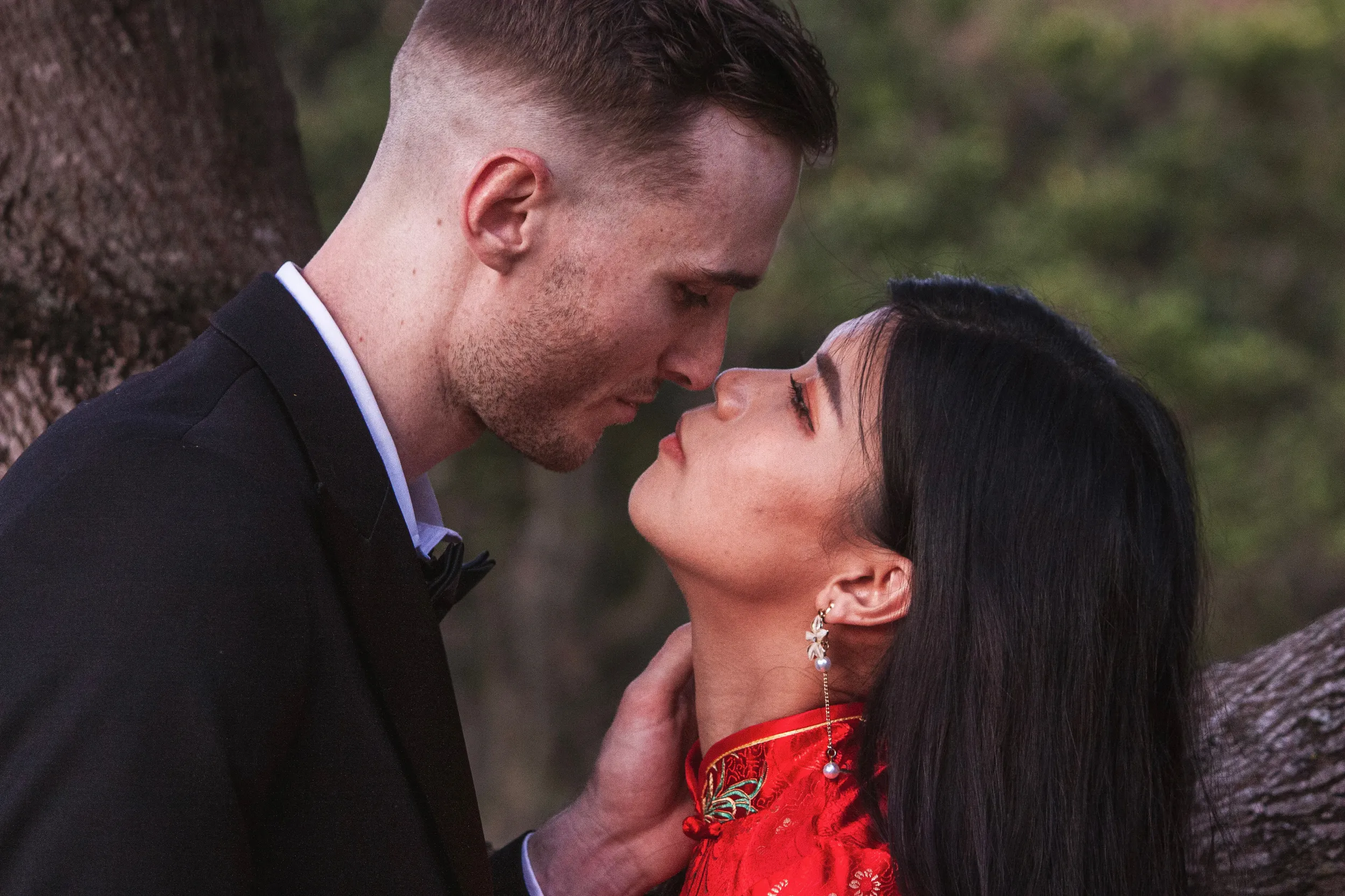 Tender engagement moment about to kiss with traditional dress in natural outdoor setting