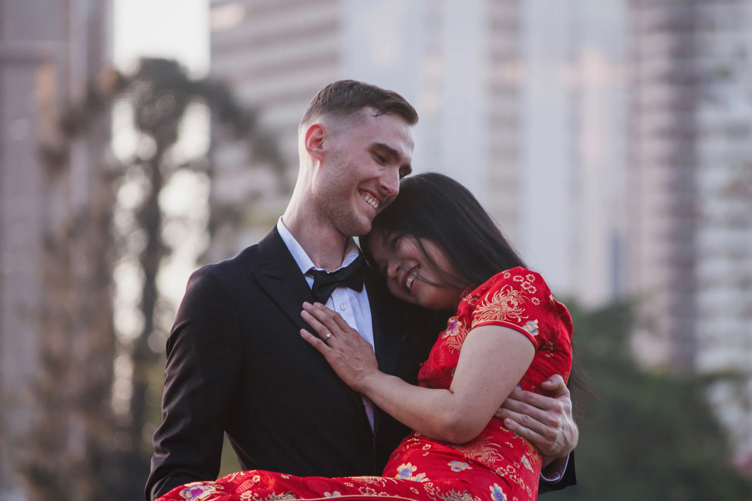 Joyful engagement photo of couple laughing together in urban setting with traditional dress