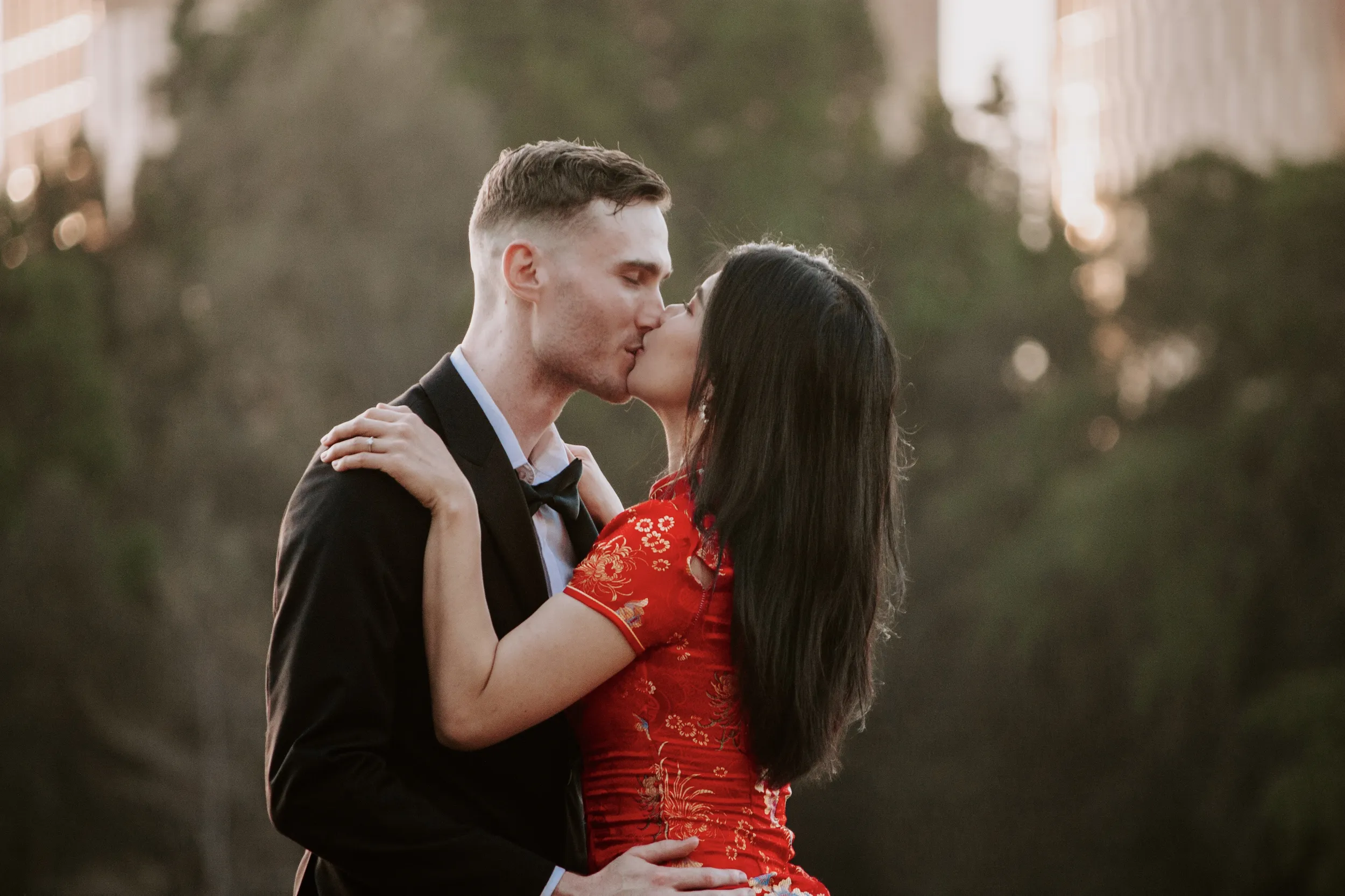 Intimate engagement kiss with beautiful golden hour lighting and natural background