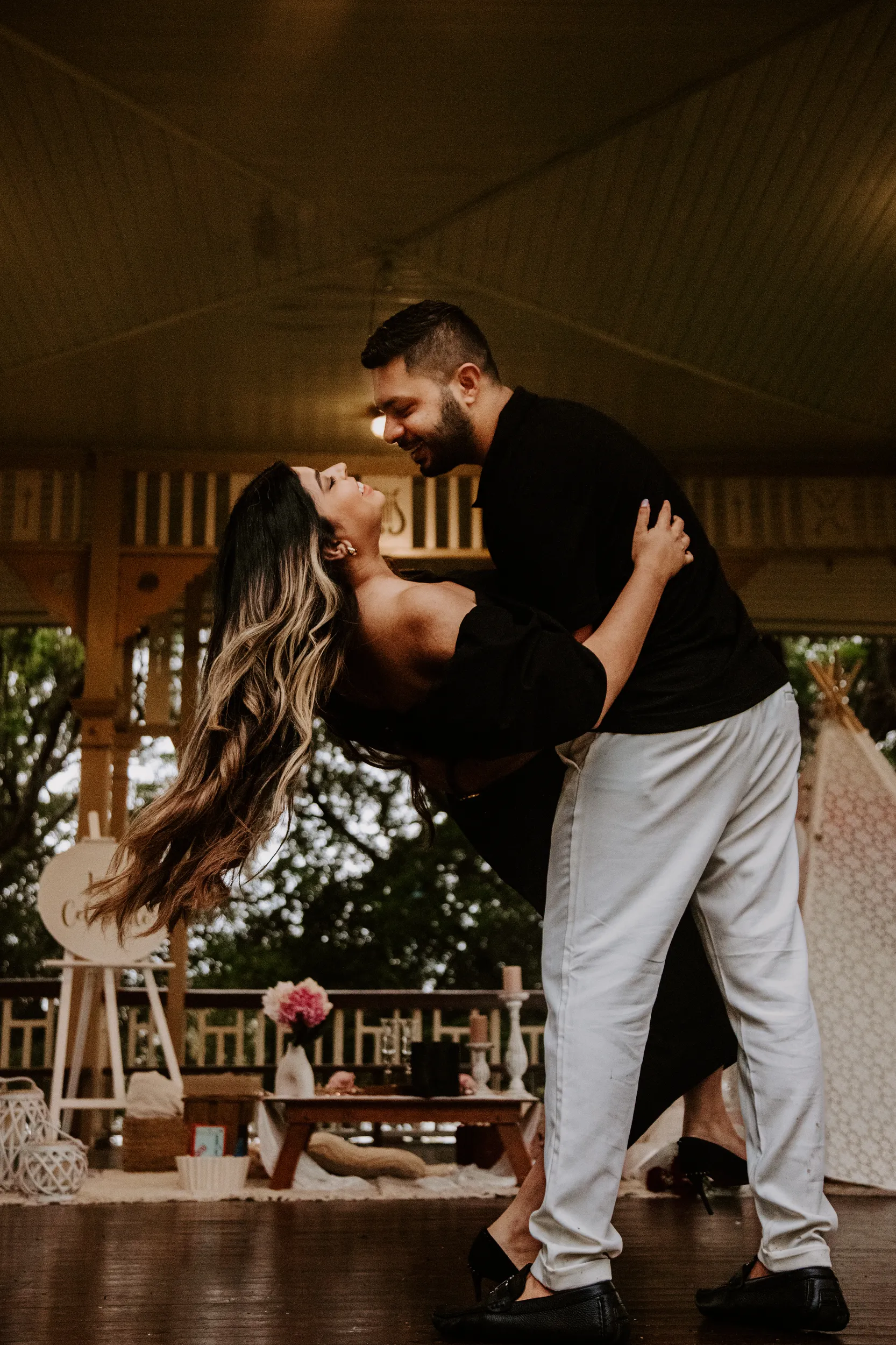 Romantic engagement photo with dance dip pose in rustic indoor setting