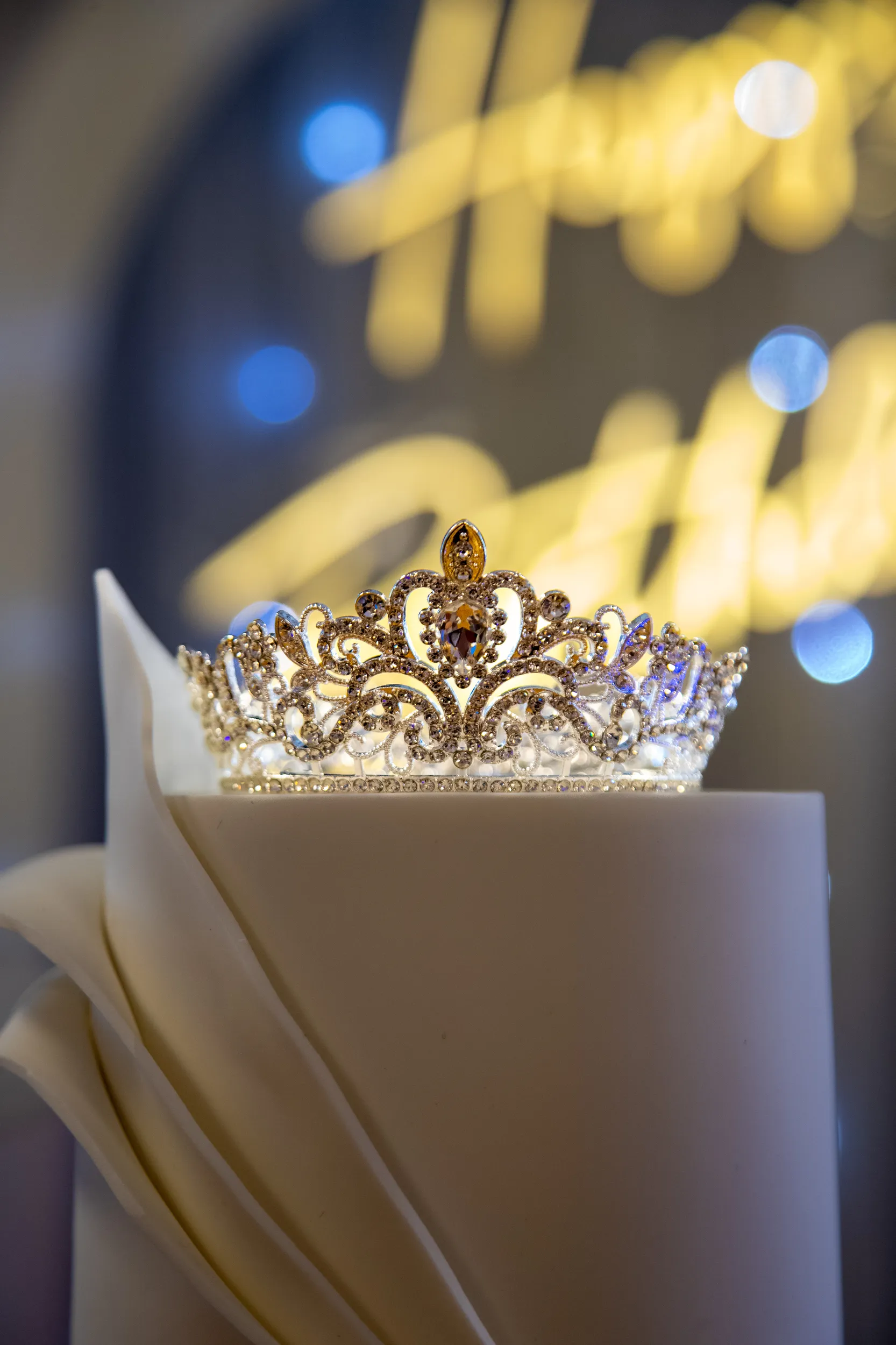 Luxurious detail shot of ornate crystal tiara with elegant bokeh lighting and dreamy atmosphere