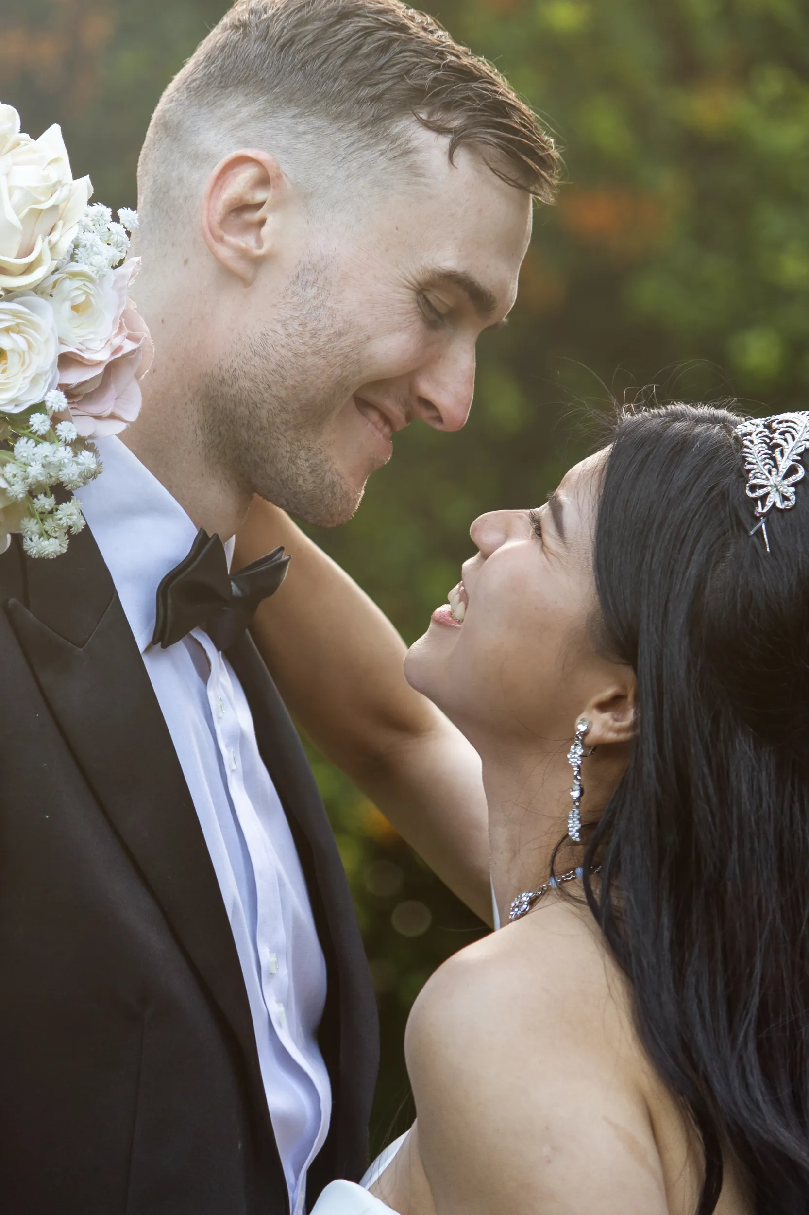 Huiyu and Chris romantic moment gazing into each other's eyes with bride's crystal hair accessory and groom in black tuxedo