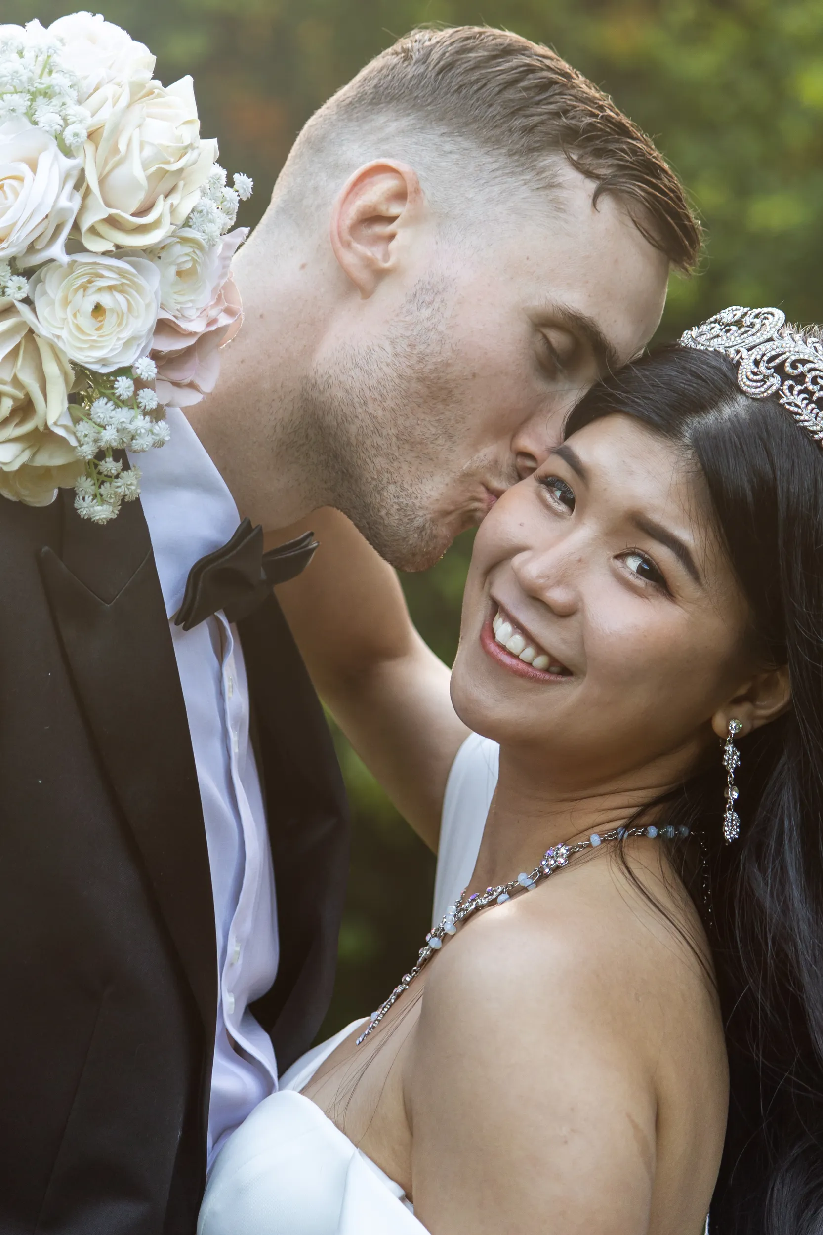 Huiyu and Chris intimate wedding portrait about to kiss with bride wearing crystal drop earrings and hair accessory