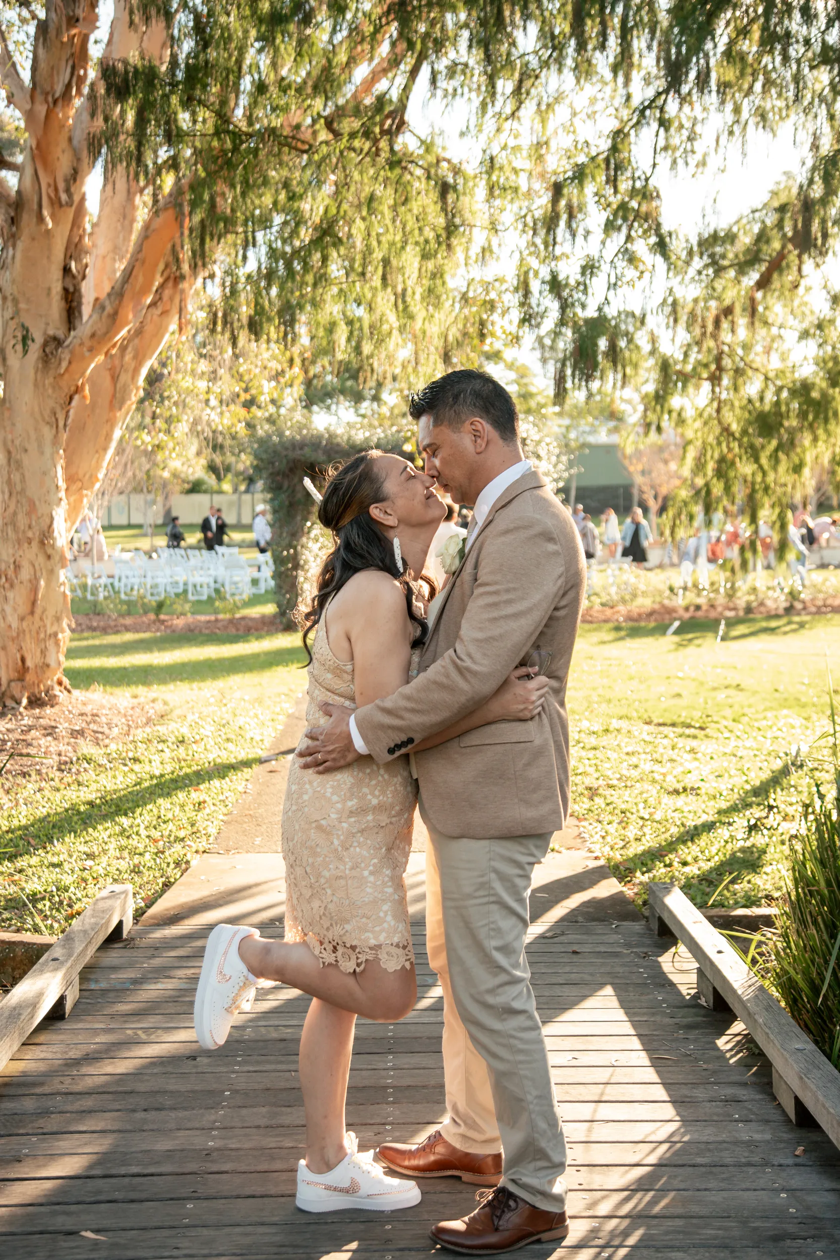 Playful romantic moment on wooden boardwalk with couple about to kiss in classic pose