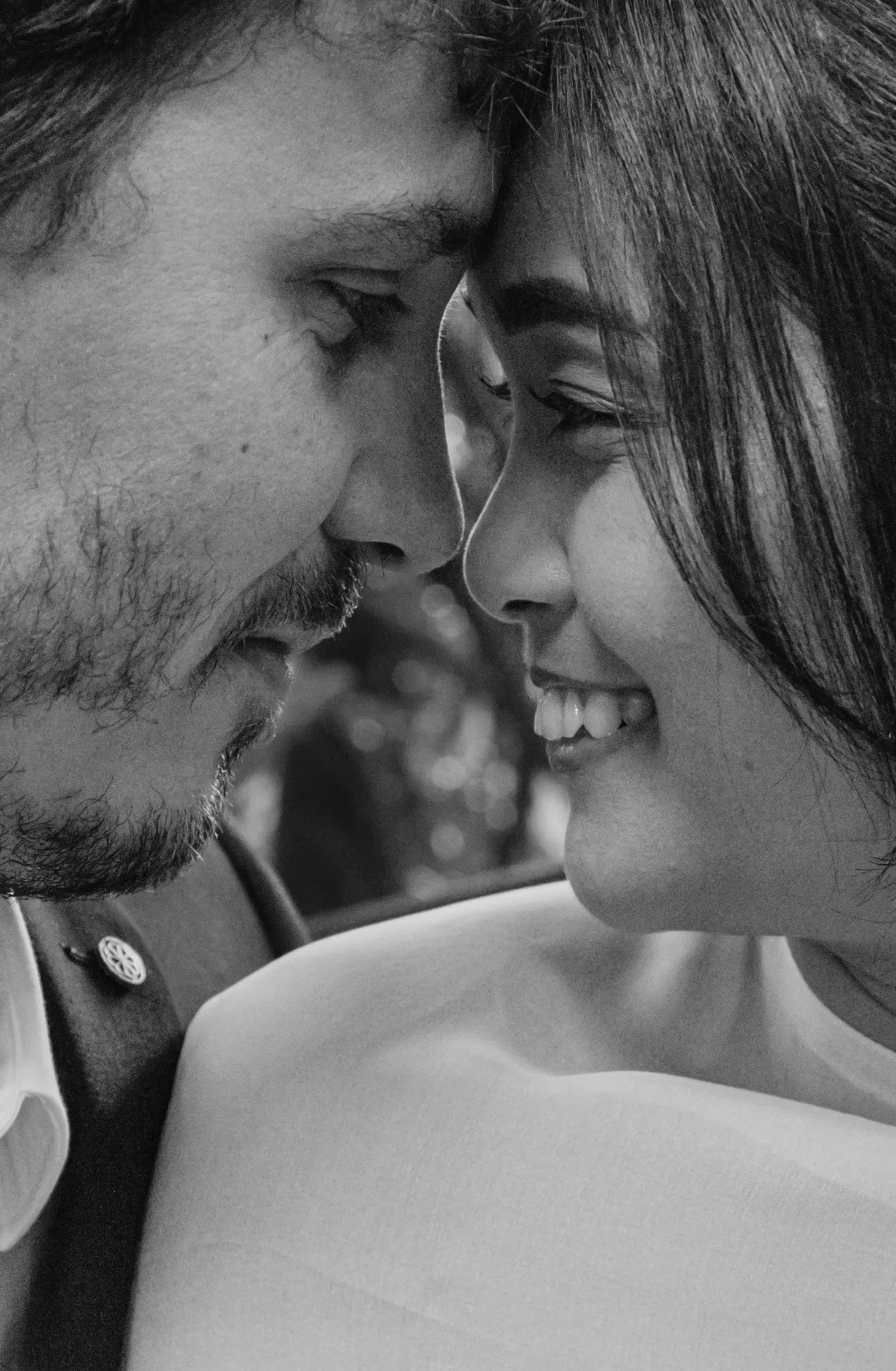 Intimate black and white wedding portrait showing close-up of bride and groom about to kiss
